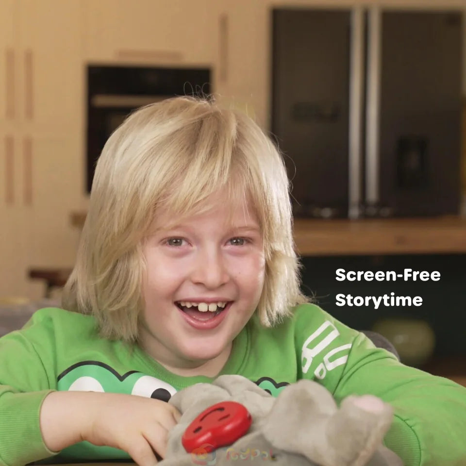 A smiling child playing with a soft toy fitted with ToyPal One